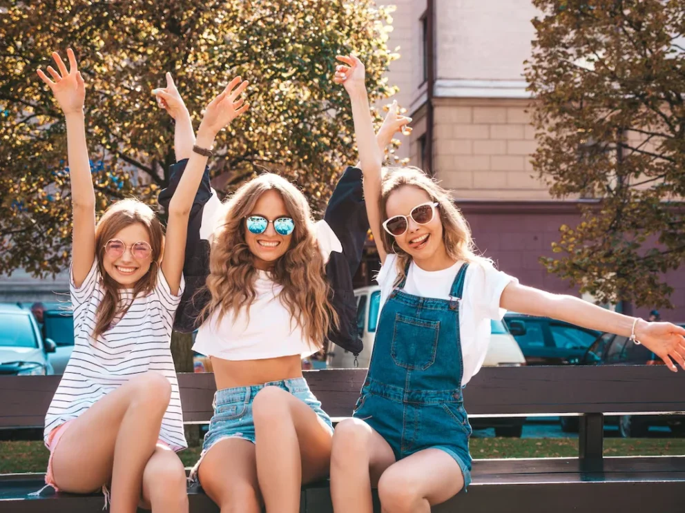 Three young woman smiling outdoors in summer